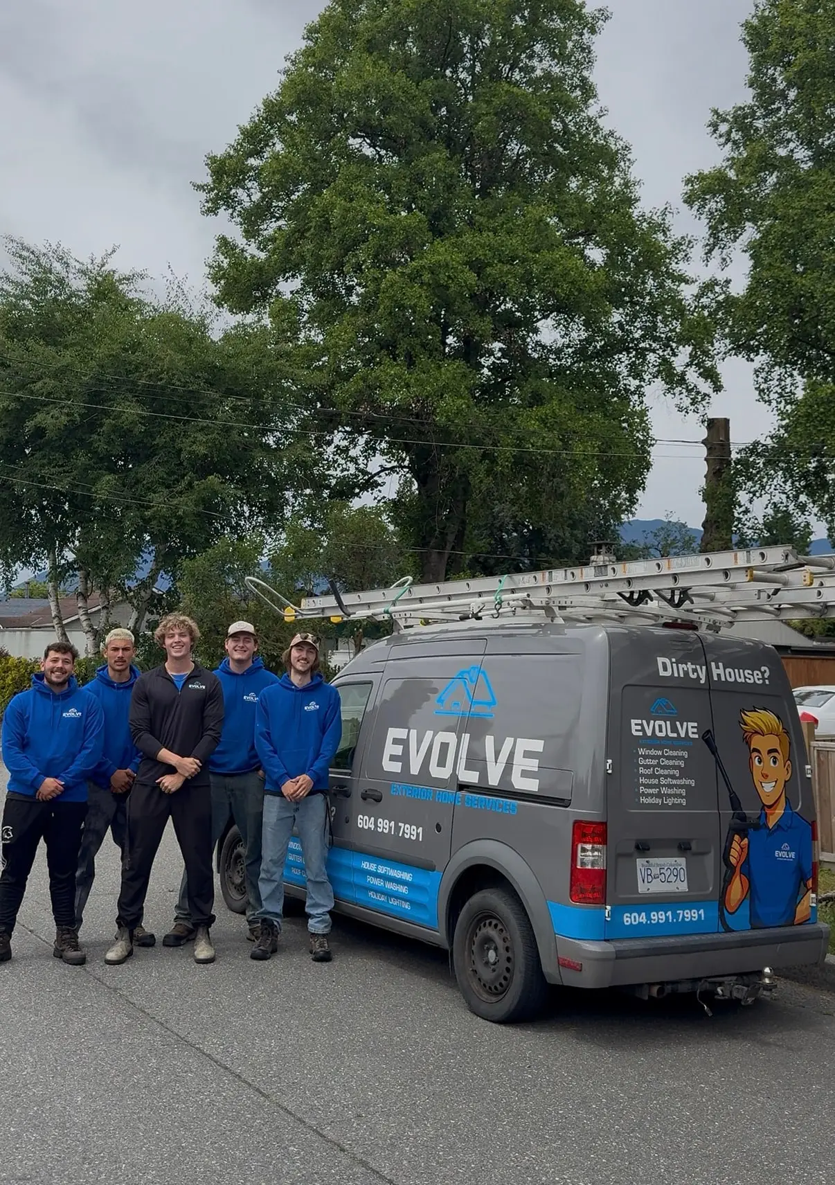 The Evolve Exterior Home Services crew standing beside the branded Evolve van