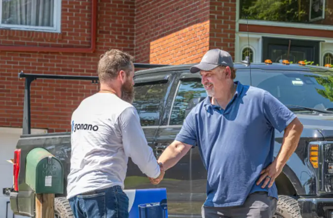 Homeowner shaking hands with a GoNano representative in front of a home
