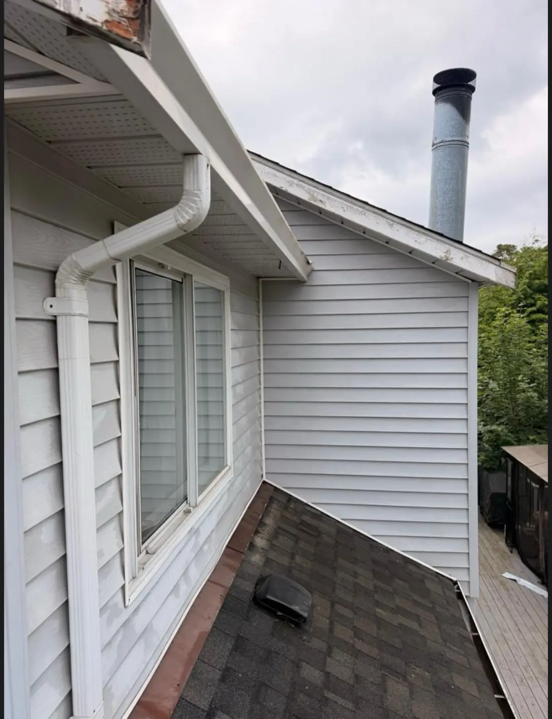 The same siding and gutter bright white after softwashing