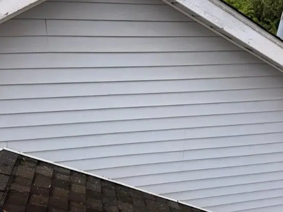 The same gable siding clean and white after a softwash
