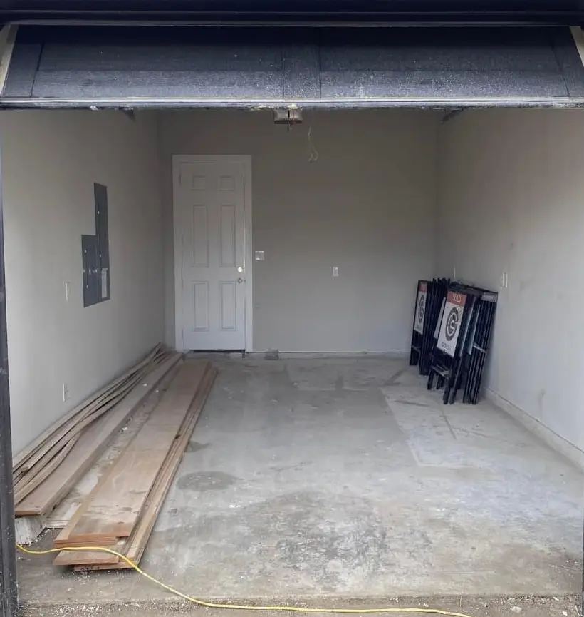 The same garage emptied, with only a few boards left against the wall