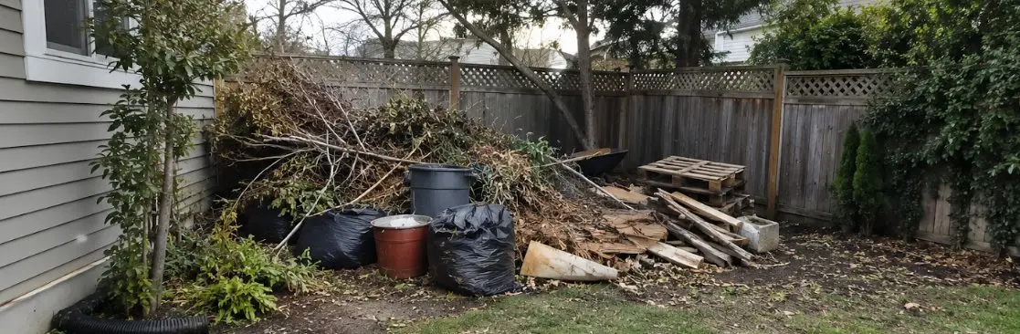 Backyard corner piled with branches and yard debris