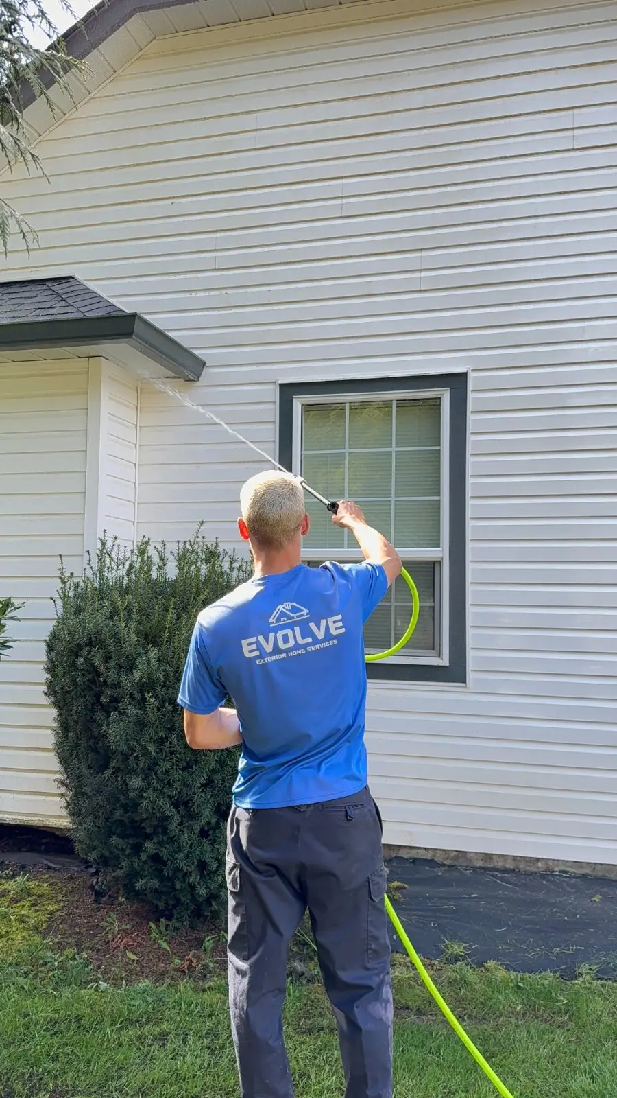 Crew member softwashing vinyl siding