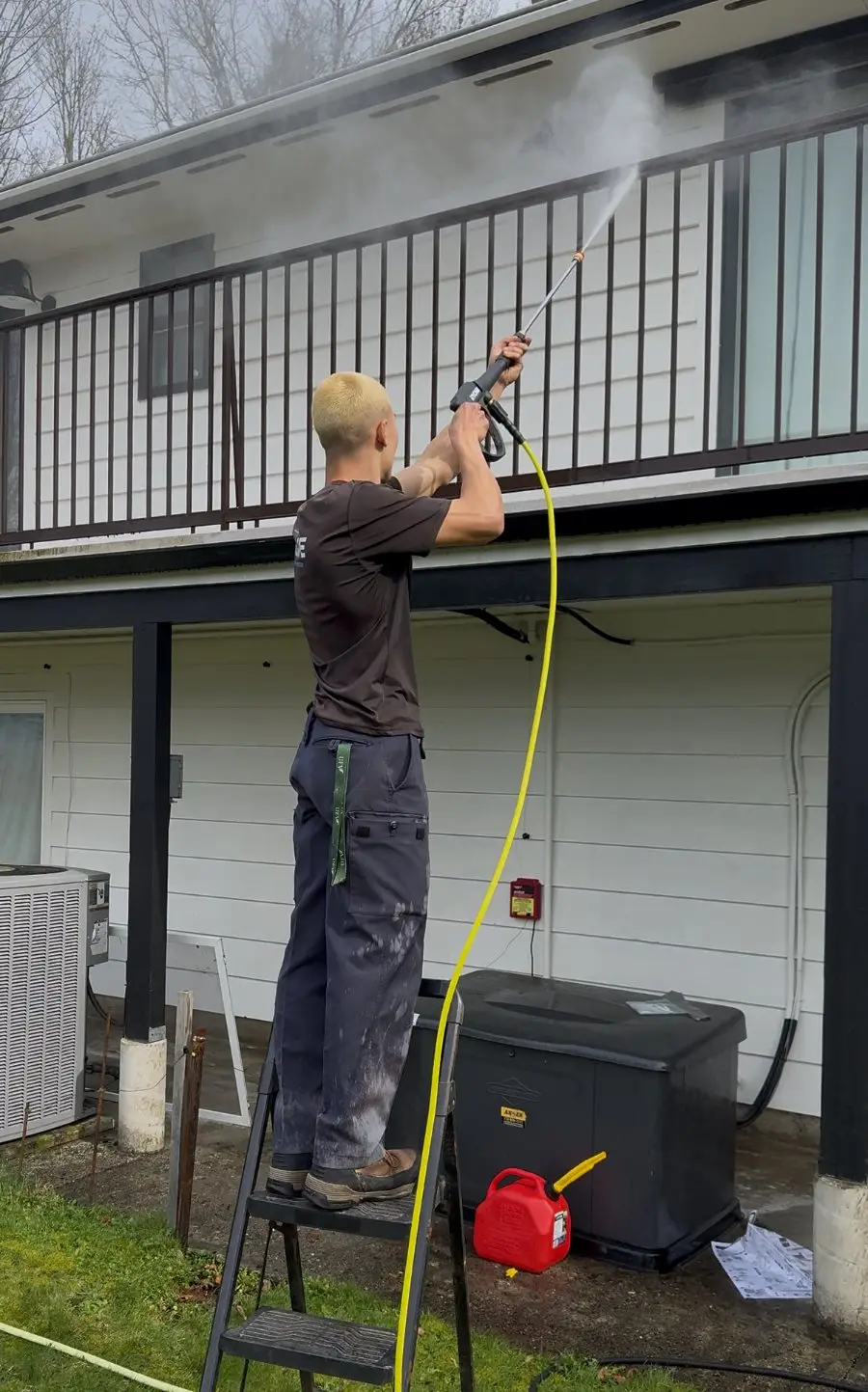 Crew member powerwashing a deck